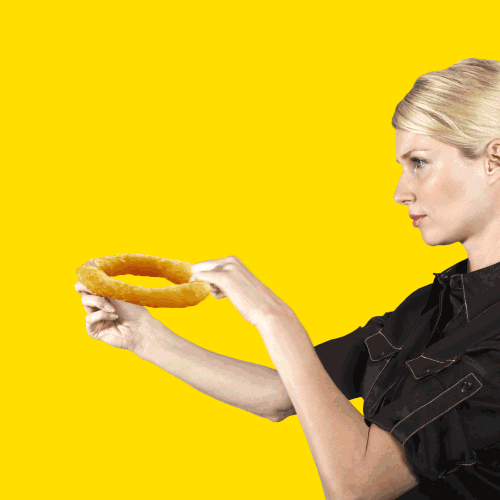 Animated GIF of a woman shooting an onion ring into a man's open mouth
